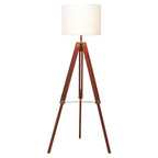 Malvern Brown Wood Tripod Floor Lamp with white linen shade and natural brown pine wood tripod legs in a warm living room setup