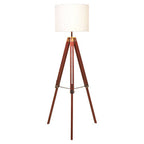 Malvern Brown Wood Tripod Floor Lamp with white linen shade and natural brown pine wood tripod legs in a warm living room setup