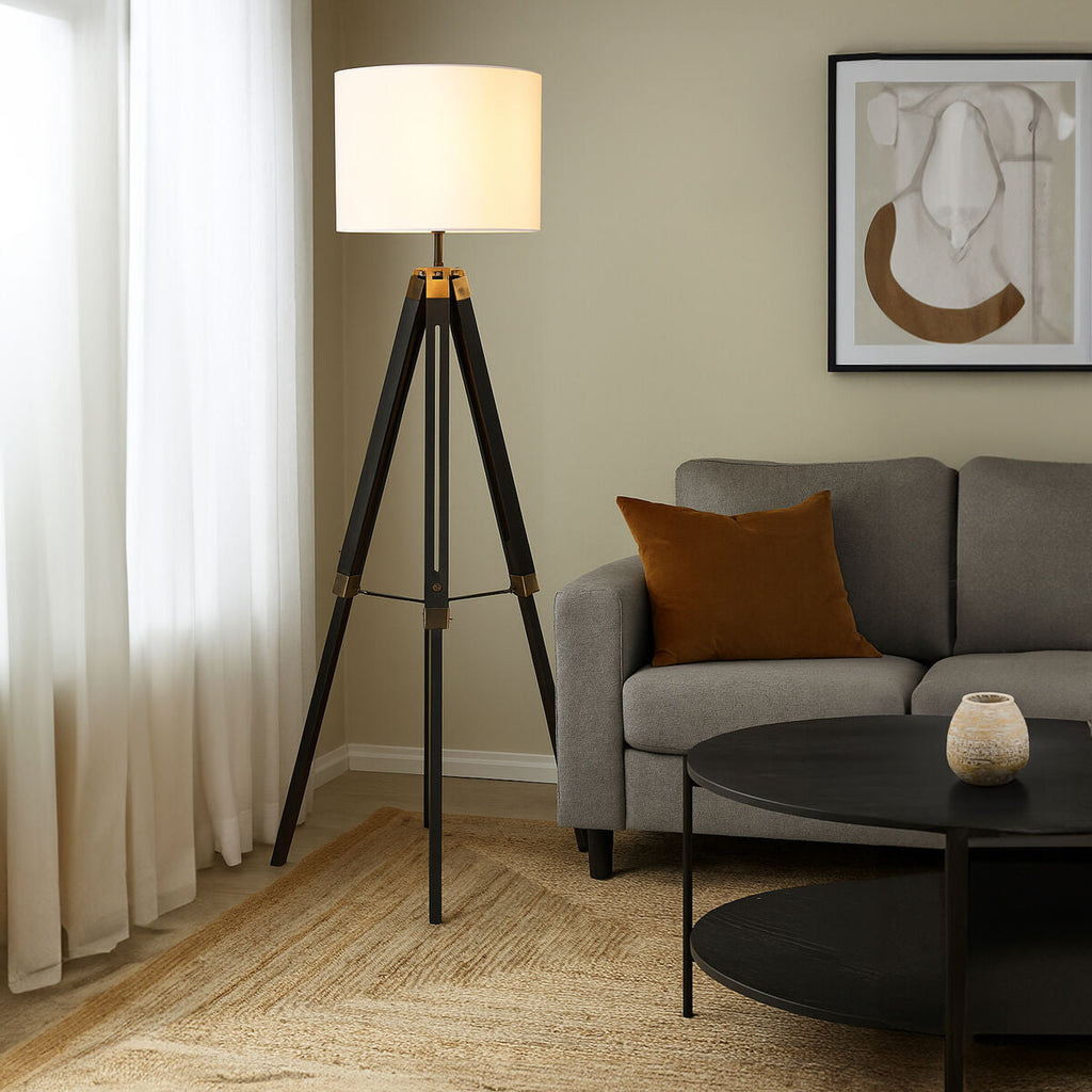 Malvern Black Wood Tripod Floor Lamp with white linen shade and black pine wood tripod legs in a modern living room