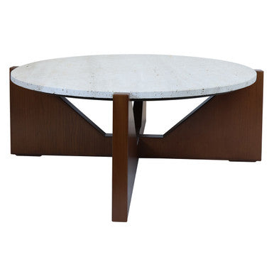 Winton Coffee Table with a round cream travertine stone top resting on an angular brown acacia wood geometric base in a modern living room