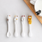 Set of 4 colorful ceramic cat spoons resting on mug rims with hang-on cup design