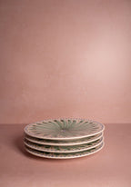 Stack of decorative plates on a pink background