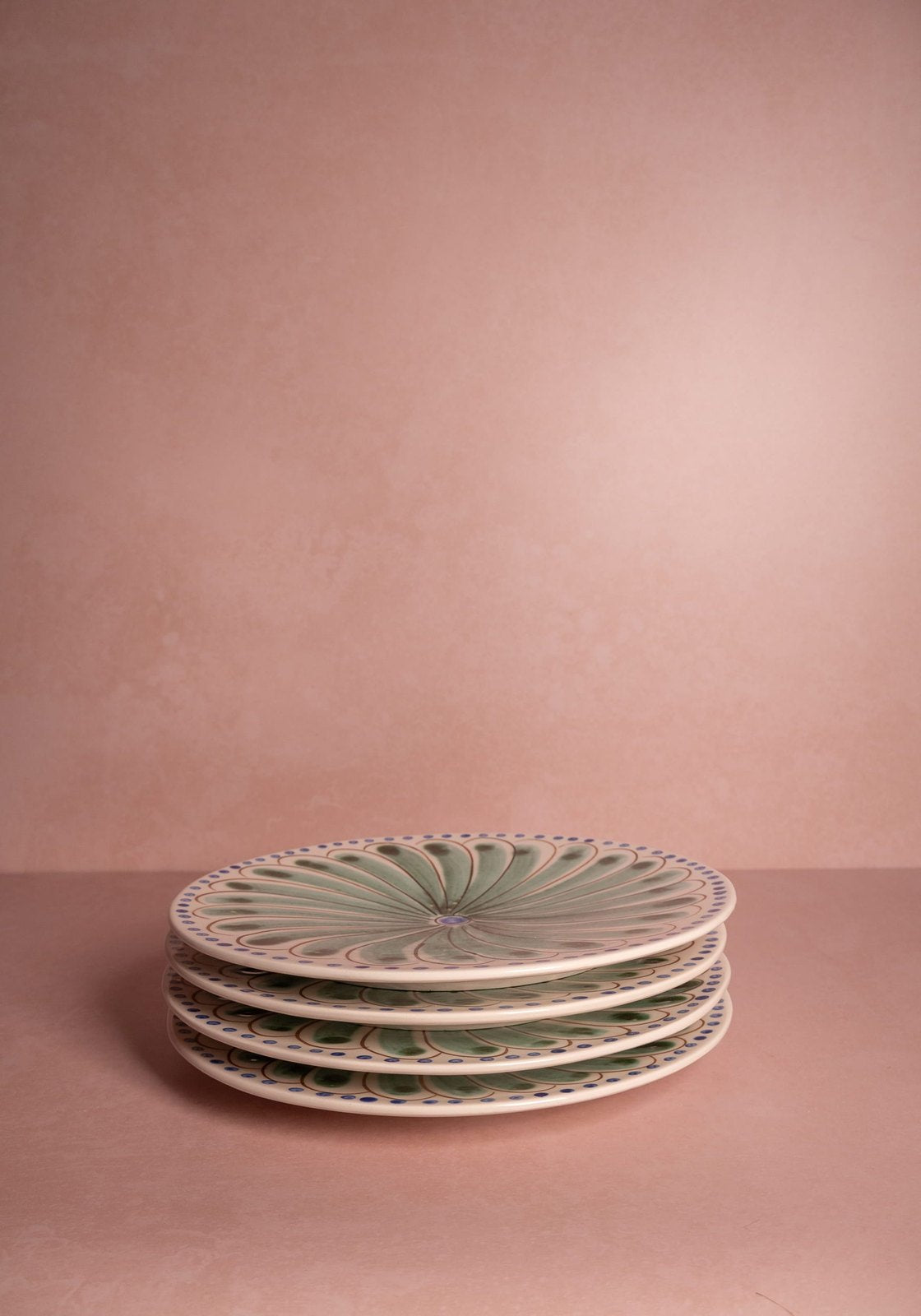 Stack of decorative plates on a pink background