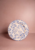Decorative plate with blue floral pattern on a pink background