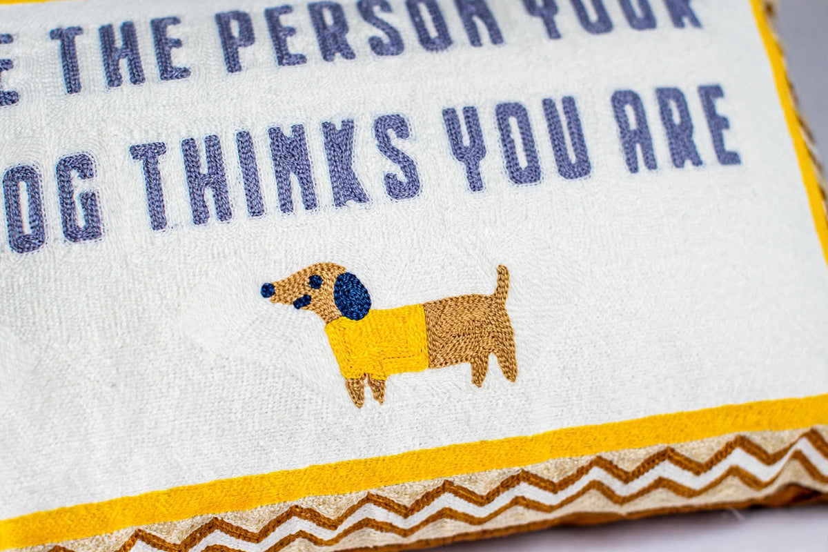 Be The Person Your Dog Thinks You Are hand-stitched needlepoint throw pillow featuring a brown dachshund design with a soft reversible velvet backing