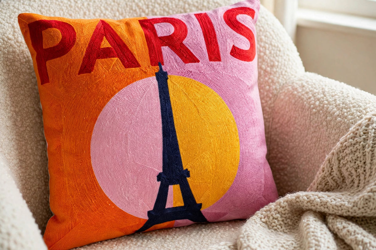 Paris Eiffel Tower hand-stitched needlepoint throw pillow featuring the Eiffel Tower against a vibrant pink and orange backdrop with a soft reversible velvet backing