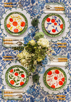 Decorative table setting with floral centerpieces and patterned plates on a blue and white tablecloth.