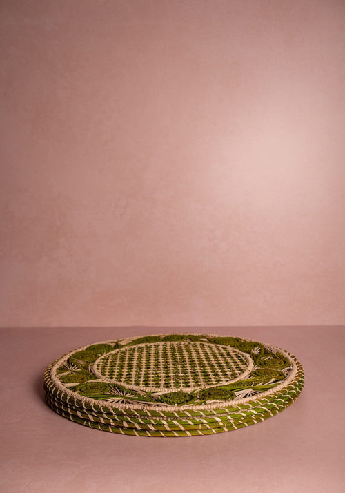 Woven green mat on a pink background