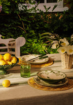 Outdoor dining setup with tableware, lemons, and flowers in a garden.